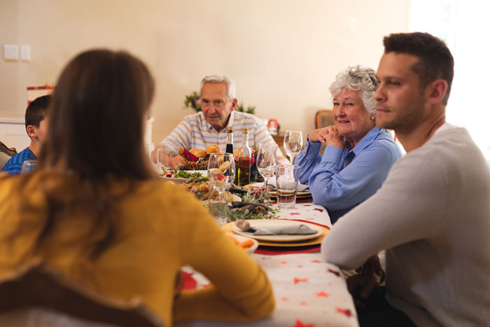 Working mom having a tense conversation with in-laws at a family dinner, addressing daycare challenges and work-life balance. Working mom having a tense conversation with in-laws at a family dinner, addressing daycare challenges and work-life balance.