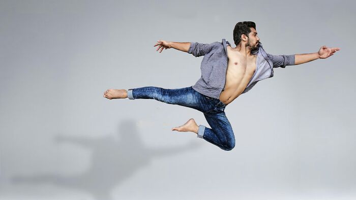 Man performing a high jump in casual clothing illustrating gender-based double standards in society.