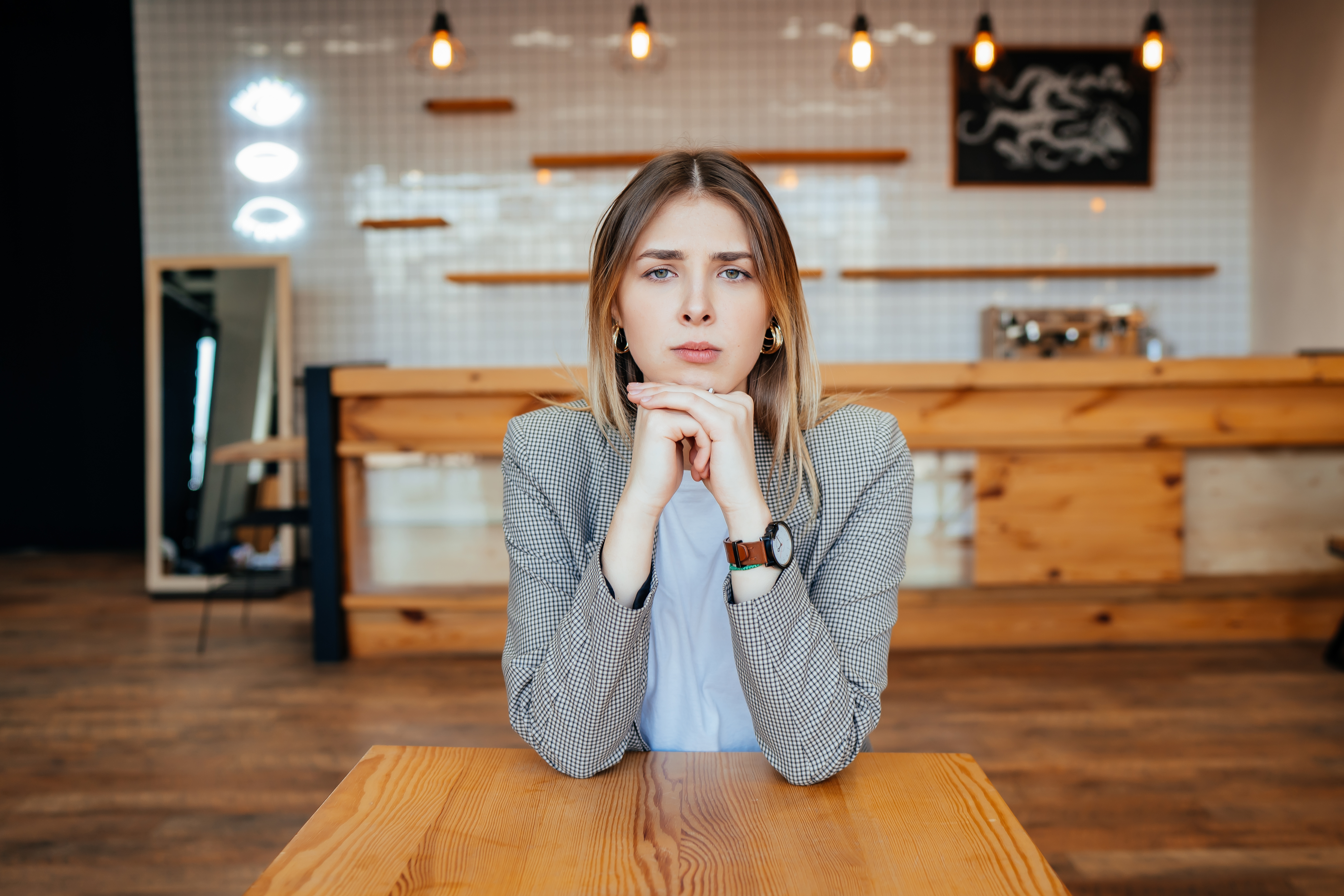 Young woman sitting alone indoors, looking thoughtful and sad, reflecting on estranged dad and cancer reconciliation. Young woman sitting alone indoors, looking thoughtful and sad, reflecting on estranged dad and cancer reconciliation.