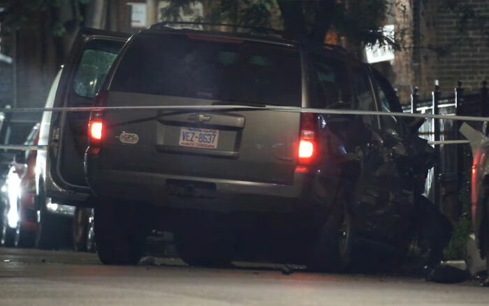 Damaged vehicle at night with rear lights on and police presence, related to maniac driver shocking response incident.