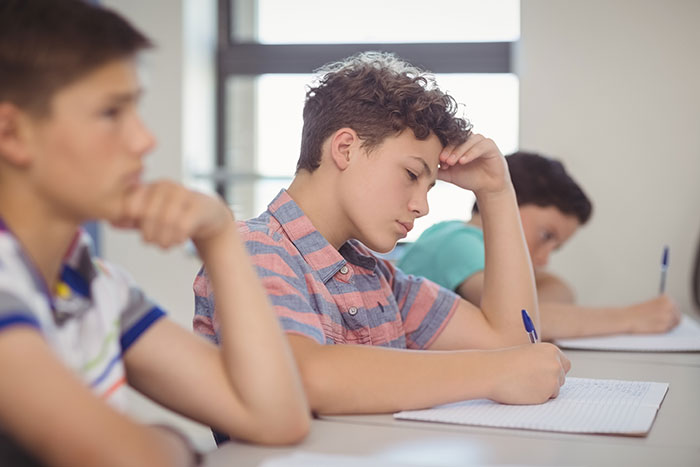 Teen student struggling with group project fails while lazy teammates expect the smart one to do all the work in classroom setting. Teen student struggling with group project fails while lazy teammates expect the smart one to do all the work in classroom setting.