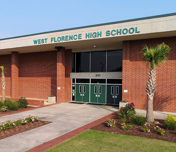 Entrance of West Florence High School with brick walls and green doors, related to teacher arrested for using poop spray incident. Entrance of West Florence High School with brick walls and green doors, related to teacher arrested for using poop spray incident.
