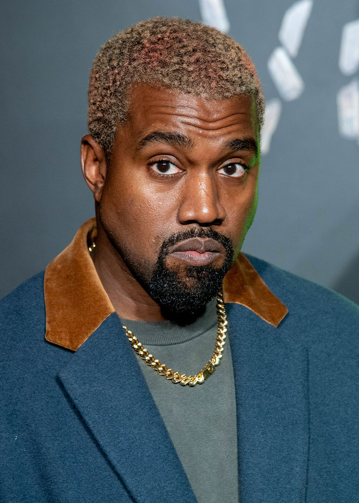 Kanye West in a blue coat and gold chain, showing a serious expression as fans react to public betrayal list involving daughter North. Kanye West in a blue coat and gold chain, showing a serious expression as fans react to public betrayal list involving daughter North.
