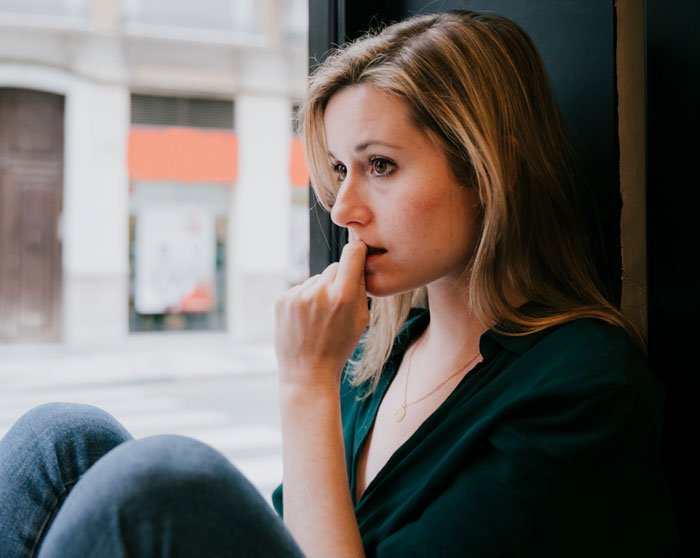 Woman sitting by window looking thoughtful and worried, reflecting on giving husband another chance and lessons learned. Woman sitting by window looking thoughtful and worried, reflecting on giving husband another chance and lessons learned.