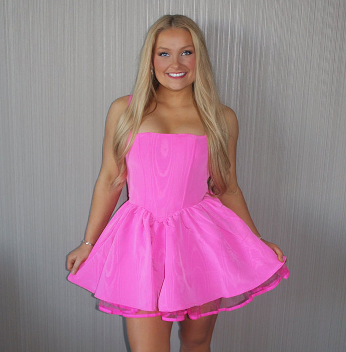 Cheerleader in a bright pink dress posing confidently, related to court appearance and pleading not guilty. Cheerleader in a bright pink dress posing confidently, related to court appearance and pleading not guilty.