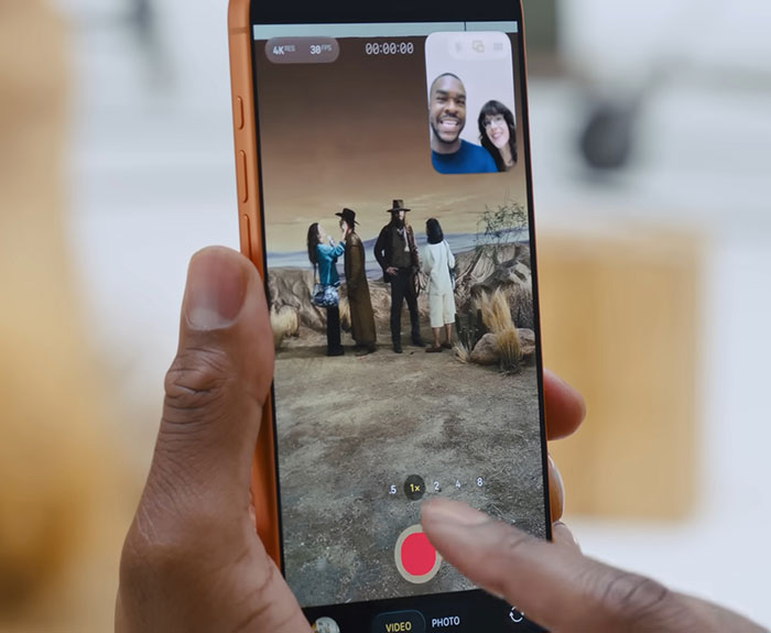 Hand holding Samsung smartphone recording video with people in desert scene, showcasing Samsung mocking new iPhone launch. Hand holding Samsung smartphone recording video with people in desert scene, showcasing Samsung mocking new iPhone launch.