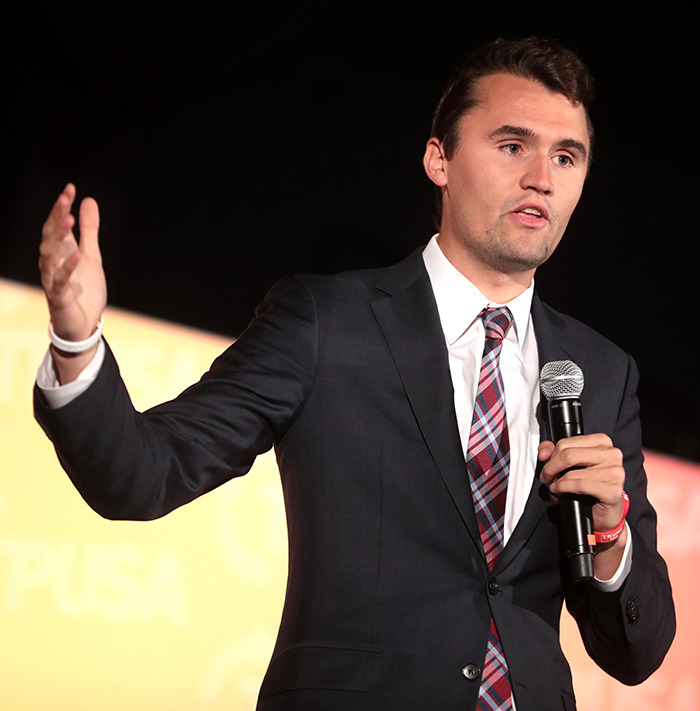 Man in suit speaking into a microphone, discussing Charlie Kirk amid The Rock's daughter firestorm remarks. Man in suit speaking into a microphone, discussing Charlie Kirk amid The Rock's daughter firestorm remarks.