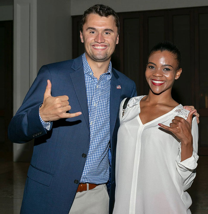 Charlie Kirk and Candace Owens smiling and posing together, both making hand gestures in a casual setting. Charlie Kirk and Candace Owens smiling and posing together, both making hand gestures in a casual setting.