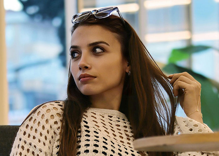 Young woman with glasses on her head, looking away with a serious expression about creepy things women do that cross the line.