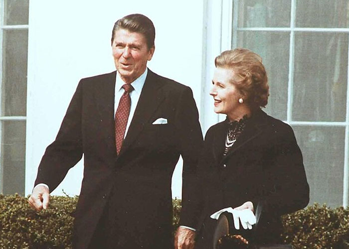 Ronald Reagan and Margaret Thatcher standing outdoors in formal attire, symbolizing historical events with societal damage.
