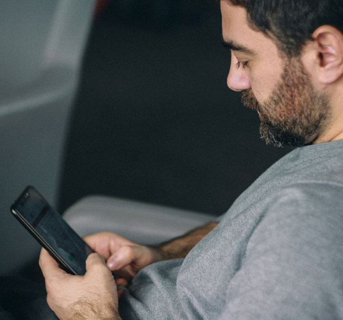 Man with beard looking at phone closely, illustrating moments when a glance at a phone changed everything quickly.