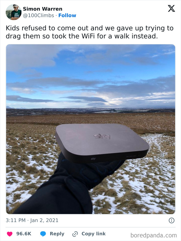 Hand holding a WiFi router outdoors in a snowy field, showcasing one of the funniest parents moments.