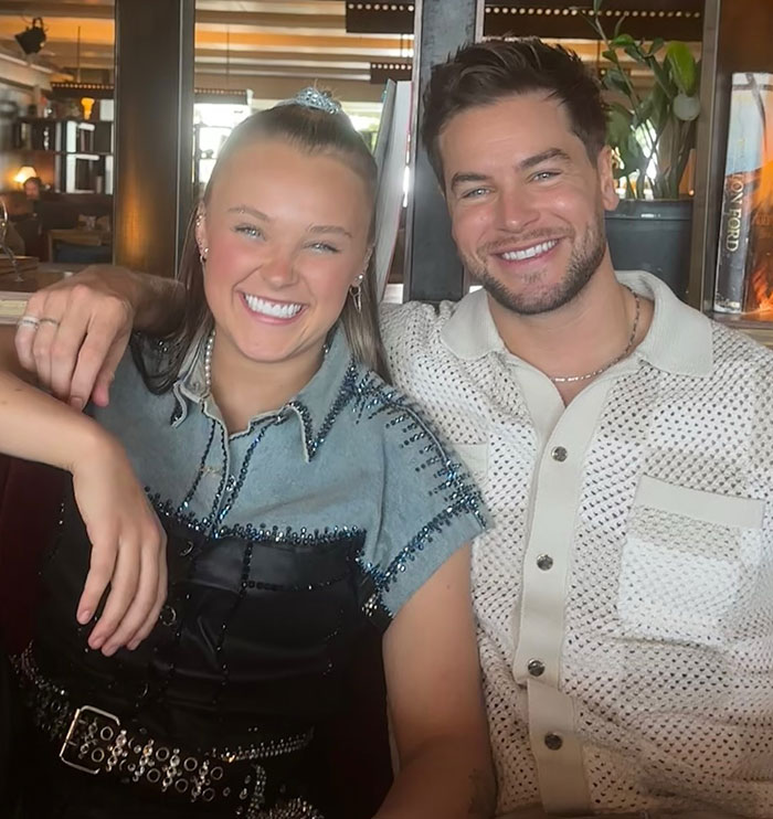 JoJo Siwa smiling with a man in casual outfits, sharing joyful moment after confessing her marriage plans. JoJo Siwa smiling with a man in casual outfits, sharing joyful moment after confessing her marriage plans.