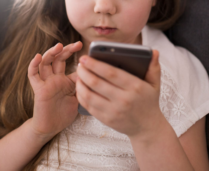 Young girl focused on a phone screen, capturing the moment when a glance at a phone changed everything instantly.