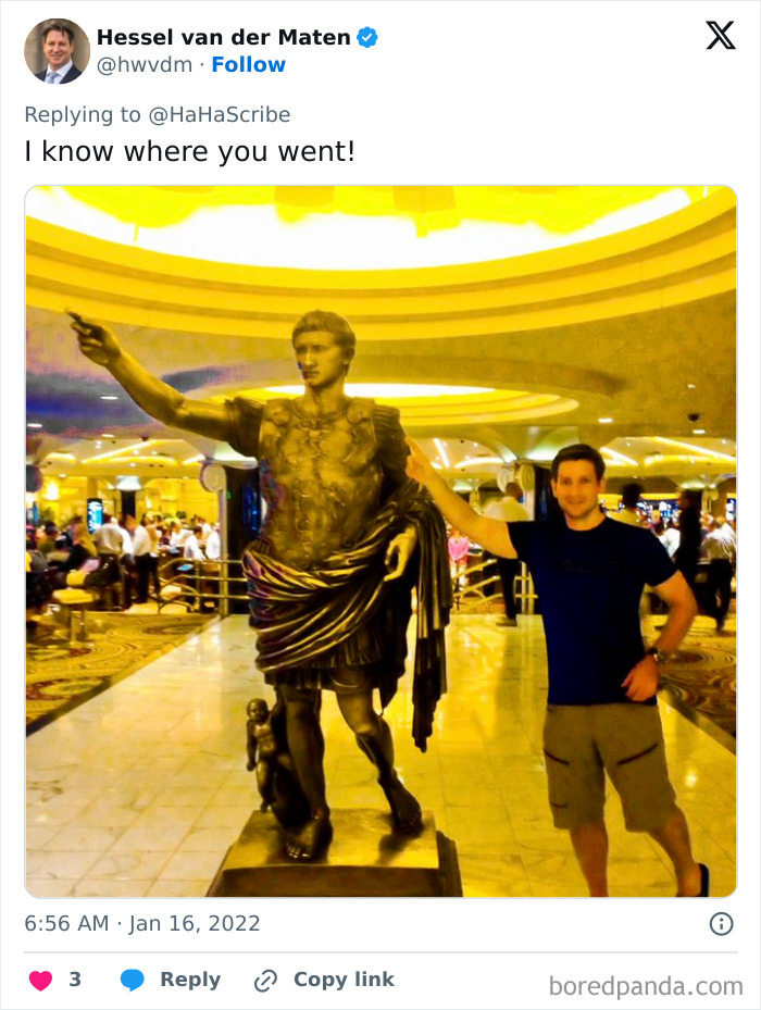 Man imitating iconic art statue pose inside a brightly lit building among a crowd in a creative and hilarious setting.