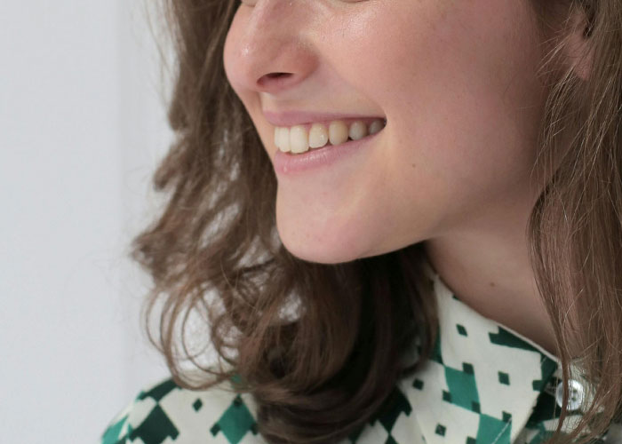 Close-up of a woman smiling, illustrating reactions to the creepiest things women do that cross the line.