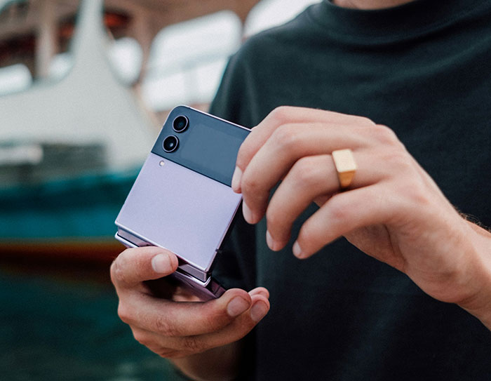 Person holding a Samsung foldable phone, highlighting Samsung's response to the new iPhone launch and brand competition. Person holding a Samsung foldable phone, highlighting Samsung's response to the new iPhone launch and brand competition.