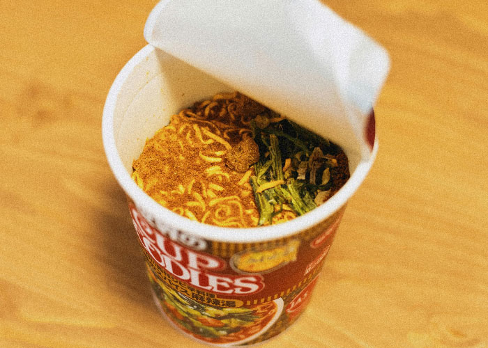 Instant cup noodles with dried vegetables on a wooden table, symbolizing mother poisoned me concerns about food safety. Instant cup noodles with dried vegetables on a wooden table, symbolizing mother poisoned me concerns about food safety.
