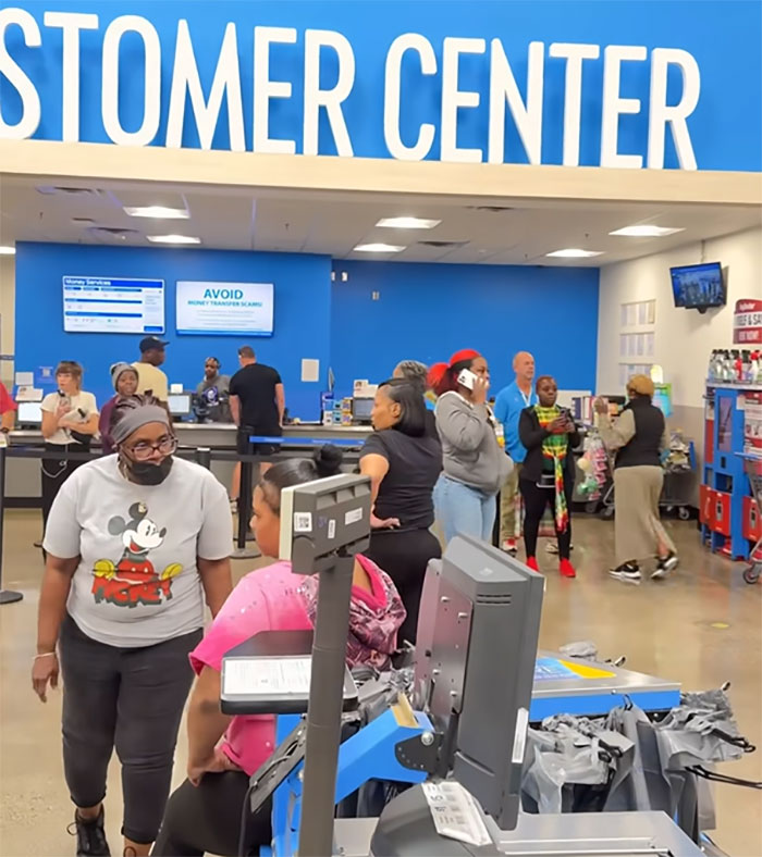 Walmart employee confronts an angry mob inside store customer center with multiple people gathered and interacting. Walmart employee confronts an angry mob inside store customer center with multiple people gathered and interacting.