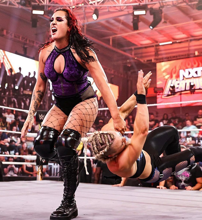 Female wrestler aggressively competing in an NXT ring, demonstrating strength and dominance during a live match event. Female wrestler aggressively competing in an NXT ring, demonstrating strength and dominance during a live match event.