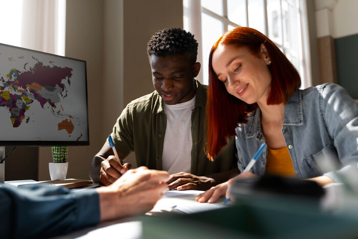 Two students studying together and smiling in a classroom, representing shocking school incidents and unusual events.