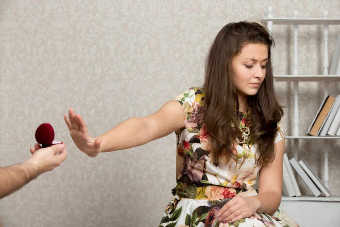 Woman in floral dress rejecting a marriage proposal, illustrating childish reasons ladies ditched a guy.