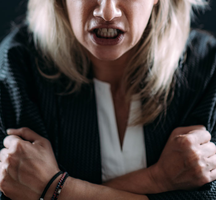 Angry woman crossing arms, expressing frustration, illustrating conflict in family caregiving for autistic brother. Angry woman crossing arms, expressing frustration, illustrating conflict in family caregiving for autistic brother.