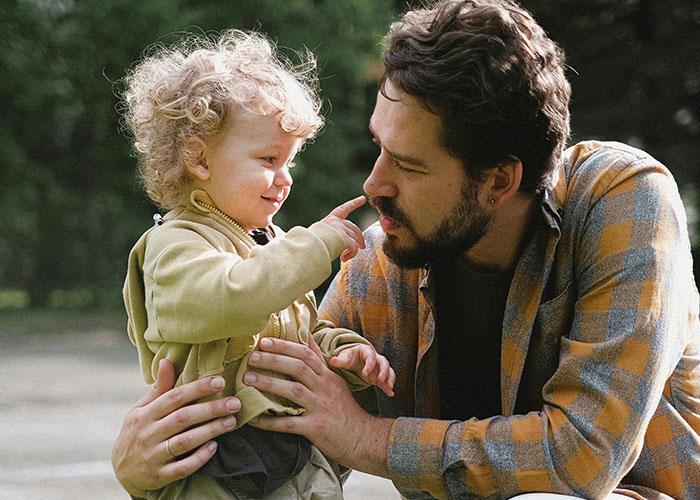 Man interacting gently with a toddler outdoors, illustrating the theme of men sharing creepy behavior that crosses the line.
