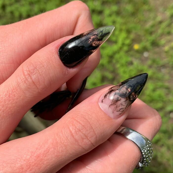 Black and n**e stiletto nails with abstract smoky designs showcasing bold and unique nail designs breaking all the rules.