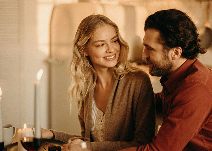 Young couple enjoying a cozy dinner at home, reflecting on common purchases ditched due to ridiculous price tags.