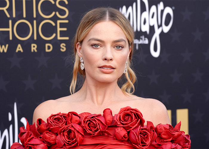 Margot Robbie at Critics Choice Awards in a red rose dress, related to Wuthering Heights teaser and 1800s theme. Margot Robbie at Critics Choice Awards in a red rose dress, related to Wuthering Heights teaser and 1800s theme.