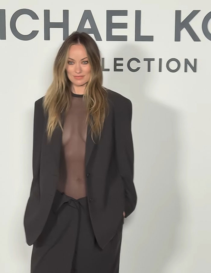 Olivia Wilde in a sheer outfit showing toned abs, wearing an oversized black blazer at New York Fashion Week event. Olivia Wilde in a sheer outfit showing toned abs, wearing an oversized black blazer at New York Fashion Week event.