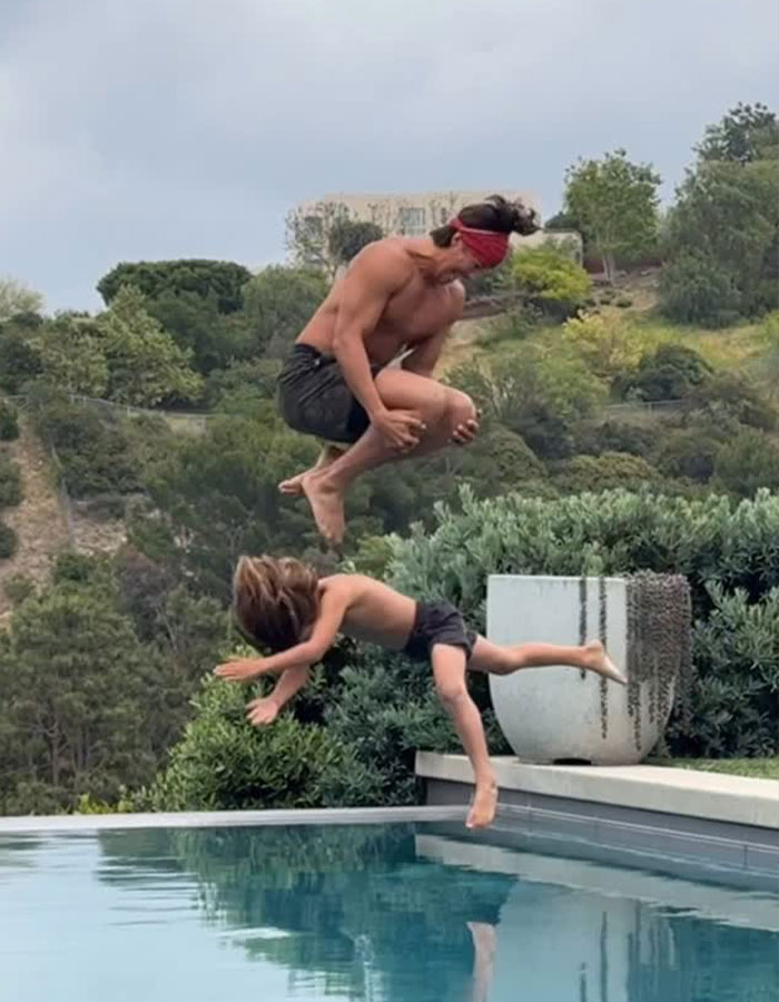 Man and child jumping into pool, capturing a moment related to dad who threw 7-year-old son off cliff viral outrage. Man and child jumping into pool, capturing a moment related to dad who threw 7-year-old son off cliff viral outrage.