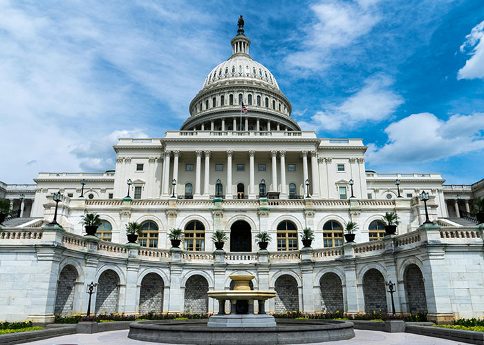 US Capitol building under a blue sky, symbolizing historical events with more damage to society than realized.