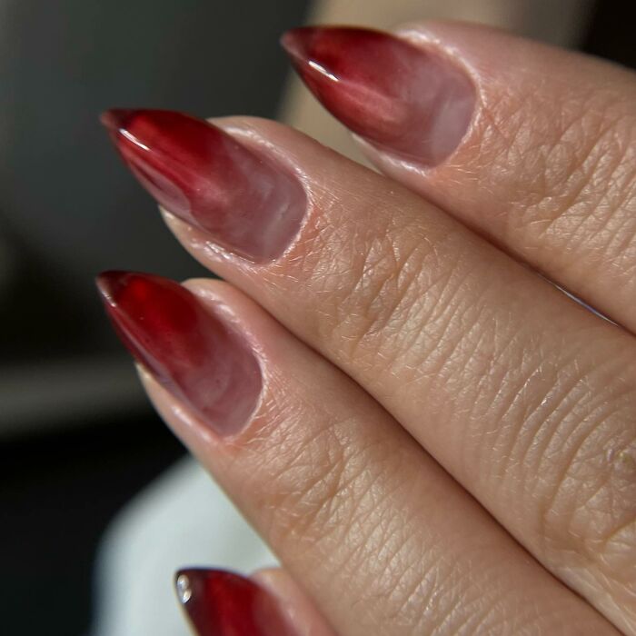 Gradient red nail designs on pointed nails, showing unique and bold nail designs breaking traditional rules.