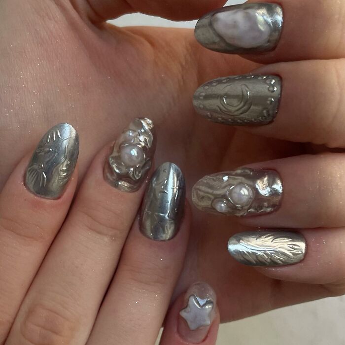 Metallic textured nail designs with 3D pearl accents showcasing unique creative nail art trends