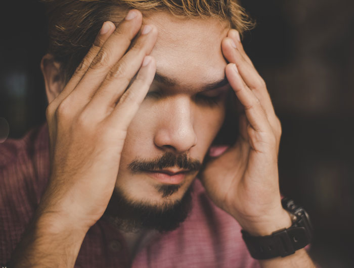 Man with beard holding his head in stress, illustrating a lesson learned the hard way about giving another chance. Man with beard holding his head in stress, illustrating a lesson learned the hard way about giving another chance.