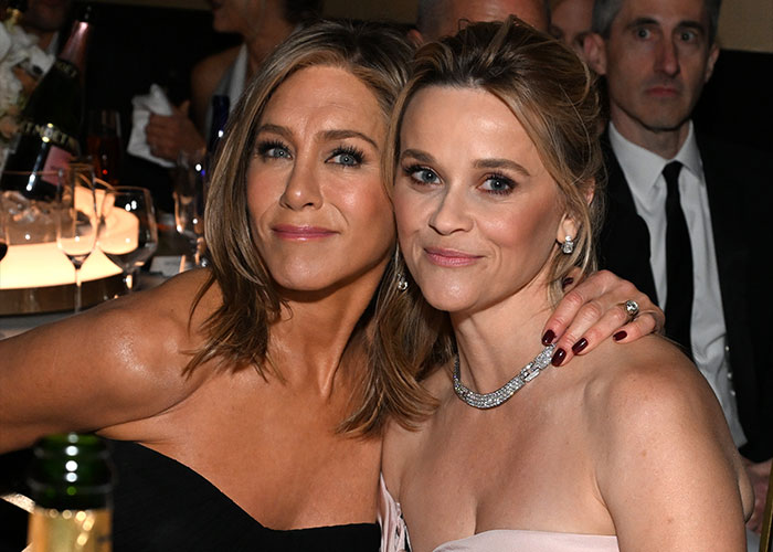 Jennifer Aniston and Reese Witherspoon smiling and posing together at a formal event, showcasing their friendship. Jennifer Aniston and Reese Witherspoon smiling and posing together at a formal event, showcasing their friendship.