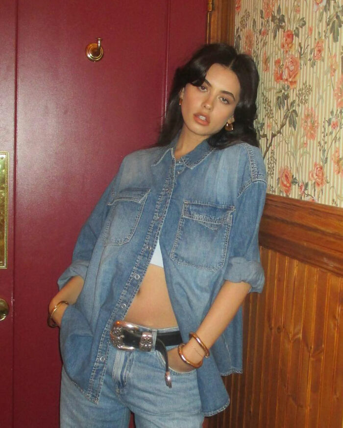 Young woman in denim outfit poses indoors, showcasing her Kybella face transformation after extreme recovery phase. Young woman in denim outfit poses indoors, showcasing her Kybella face transformation after extreme recovery phase.