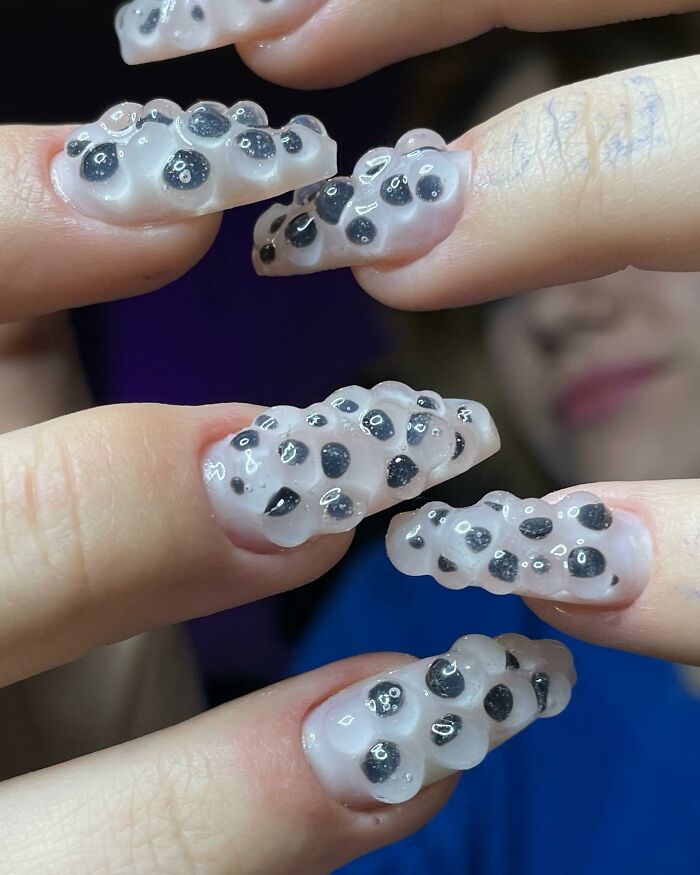 Unique 3D textured nail designs with black spots on translucent nails, showcasing bold and creative nail designs.