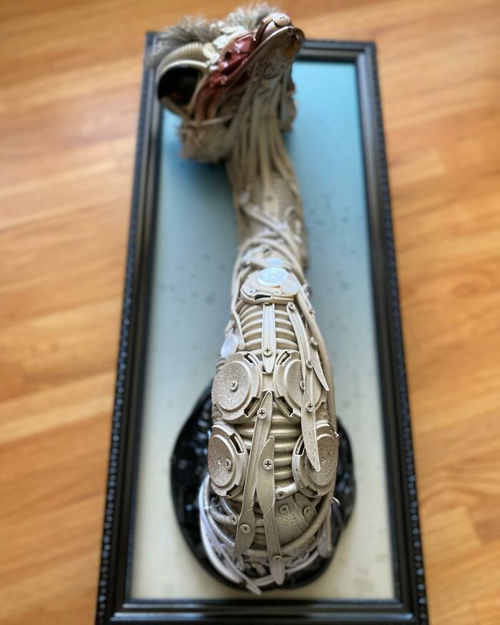 Sculpture of an animal made from trash, featuring intricate details and framed against a blue background.