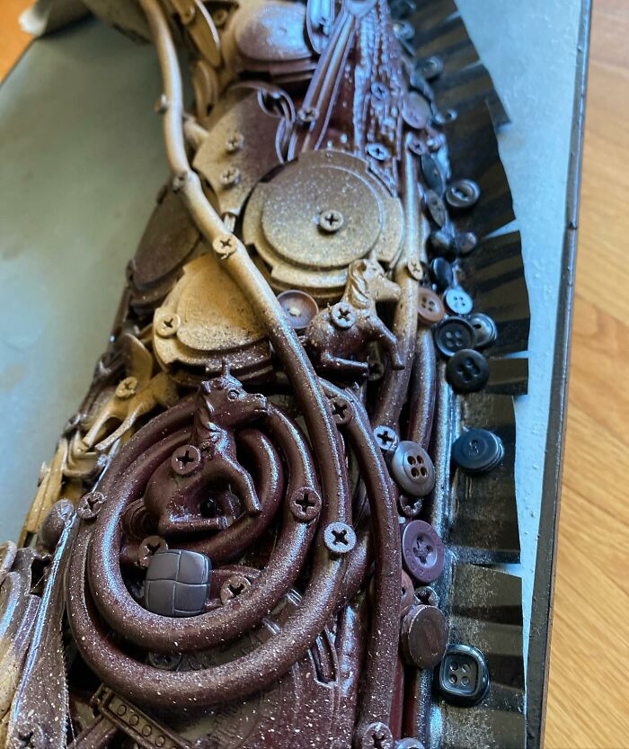 Sculpture of a giraffe made from trash, showcasing stunning animal art crafted with recycled materials on a wooden floor.