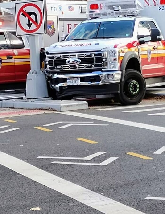 Ambulance truck parked by the curb beneath a no U-turn sign, reflecting typical EMT and paramedic emergency response vehicles.
