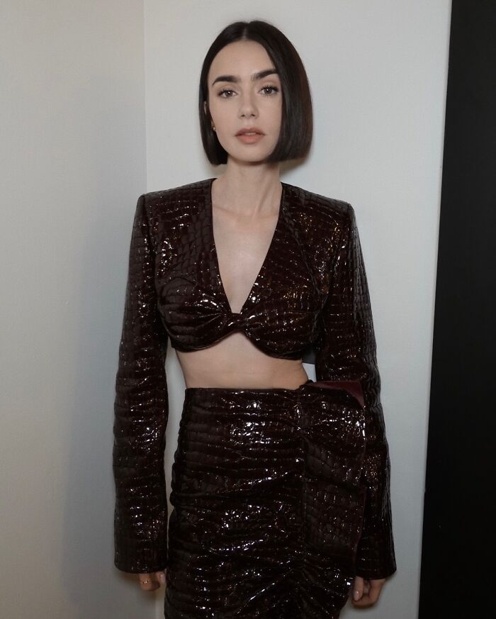 Lily Collins posing in a shiny dark cropped top and skirt, highlighting her extreme thinness and slender figure. Lily Collins posing in a shiny dark cropped top and skirt, highlighting her extreme thinness and slender figure.
