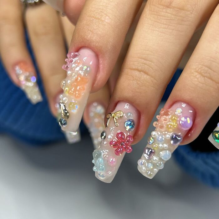 Long acrylic nails with colorful 3D nail designs and gems, showcasing creative and unique nail art styles.