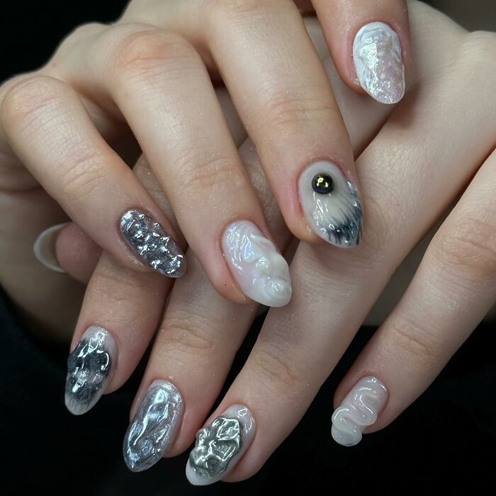 Unique silver and white nail designs with textured, glossy 3D effects showcasing bold and creative nail art styles.