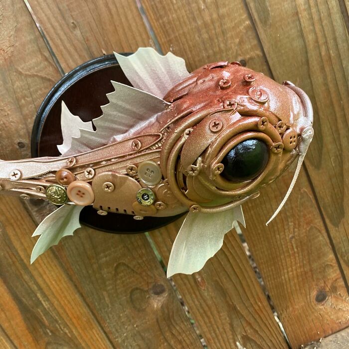 Steampunk-style fish sculpture made from recycled trash materials showcasing creative animal sculptures by an innovative artist.