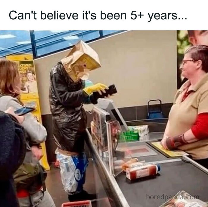Person wearing improvised protective gear while checking out at a store in a funny history meme.