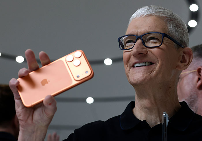 Tim Cook holding a new iPhone with a smile, highlighting the iPhone launch as Samsung mocks the device. Tim Cook holding a new iPhone with a smile, highlighting the iPhone launch as Samsung mocks the device.