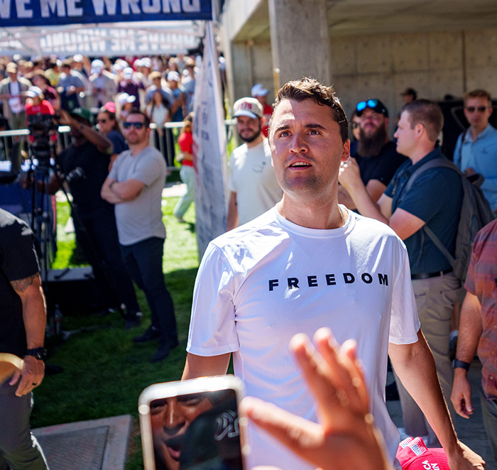 Man wearing a white freedom t-shirt at a crowded outdoor event after Utah tragedy commentator remarks controversy. Man wearing a white freedom t-shirt at a crowded outdoor event after Utah tragedy commentator remarks controversy.